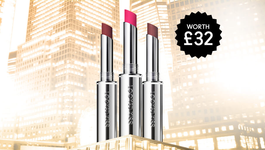 three locked kiss lipsticks on a gold city background